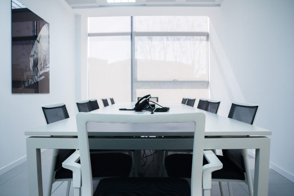 Mesa de reuniones en blanco con sillas ergonómicas transpirables