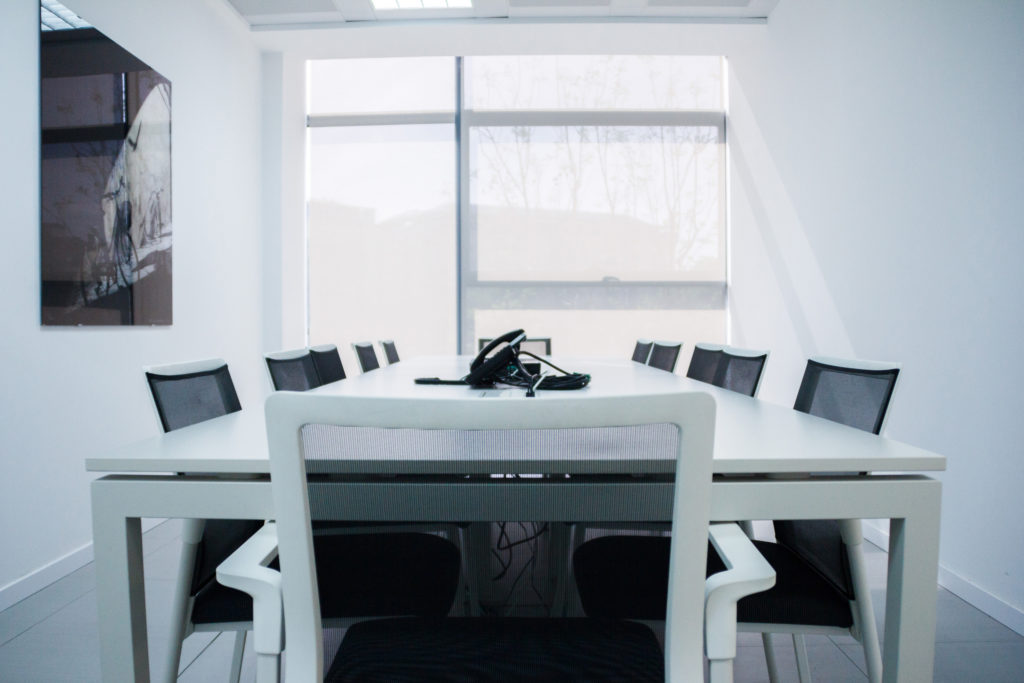 Mesa de reuniones blanca con sillas de respaldo transpirable