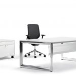 Mesa de oficina en color blanco y silla ergonómica negra con respaldo transpirable