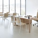 Mobiliario de oficina en madera y sillas en colores crema