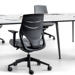 Mesa de oficina blanca con sillas ergonómicas de color negro