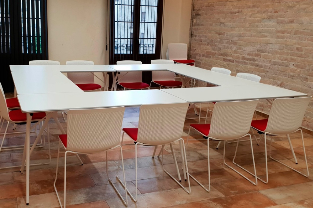 Mesa de reuniones en color blanco con sillas de color blanco y rojo