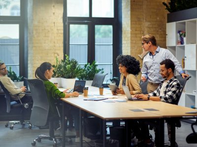 Office life. Group of young multiracial people sitting at the table in coworking space and working