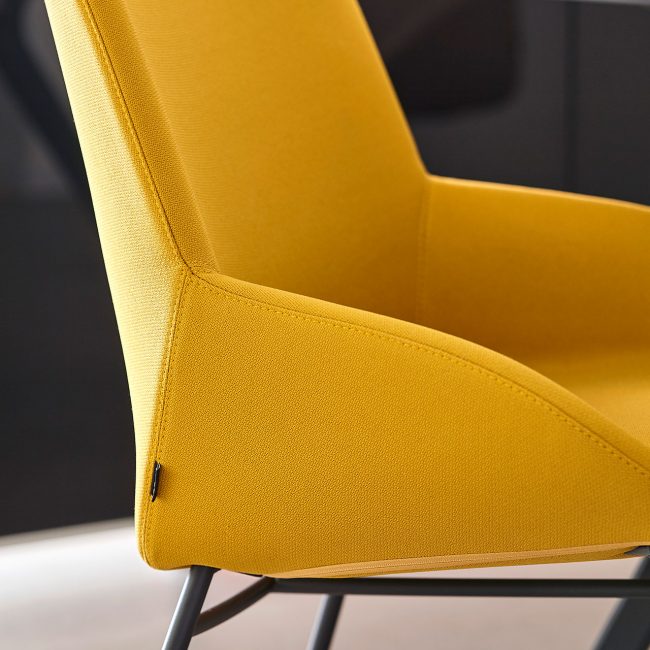 Detalle de silla de oficina en amarillo y patas en color negro